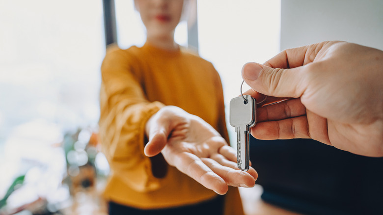 Close-up shot of a real estate agent giving a woman the keys to her new home.