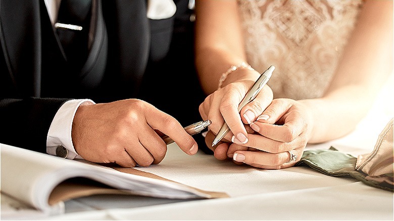 Married couple signing forms