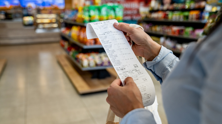 Women checking grocery recipt.