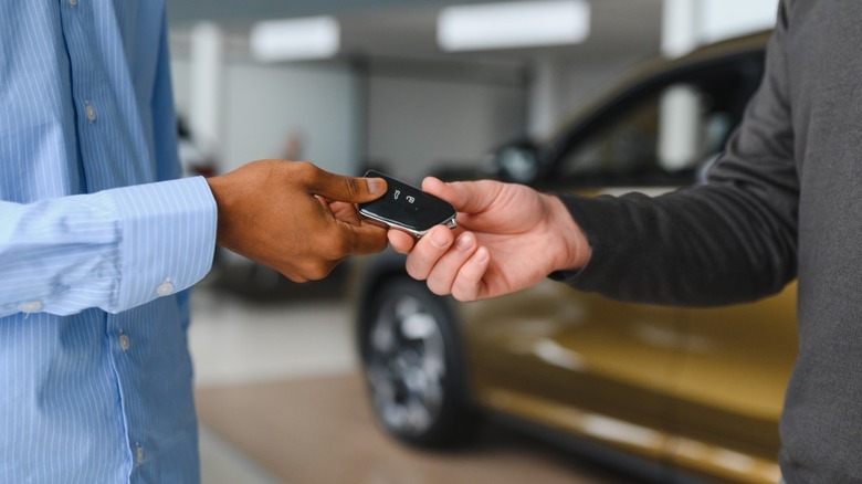 Keys being handed off at a car dealership.