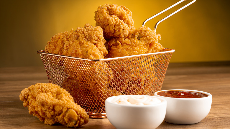 fried chicken in a basket with sauces