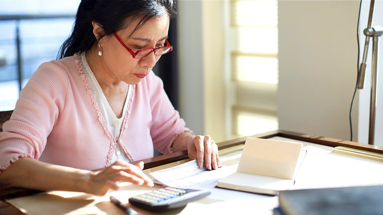 Person crunching numbers with calculator