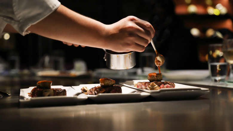 Chef plating a steak dish