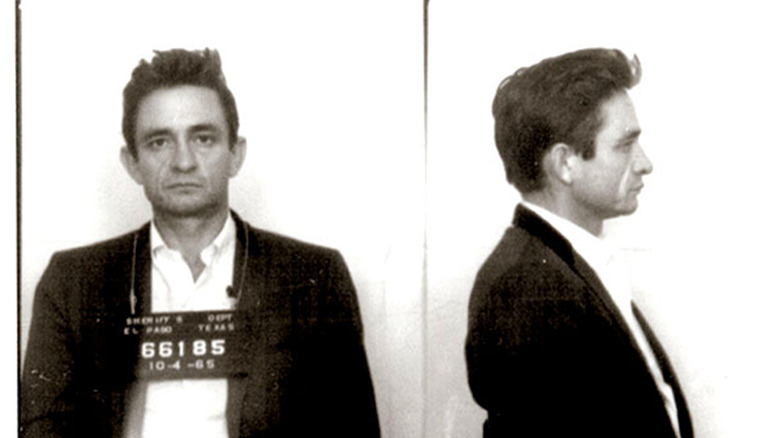 Johnny Cash posing for a mugshot in 1965