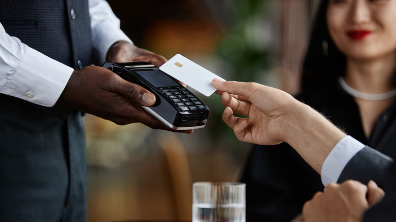 Person paying at restaurant with card.