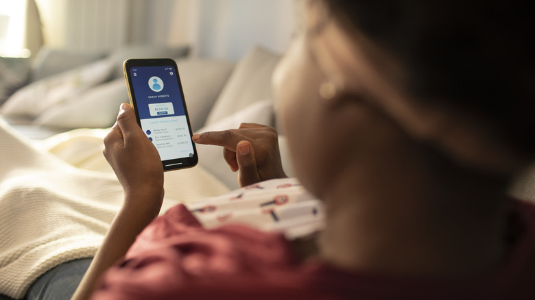 Woman looking at Venmo account balance on smartphone