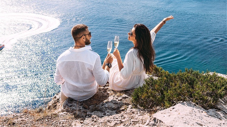 Couple celebrating outside near water