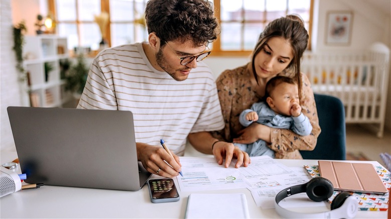 Couple with baby reviewing finances