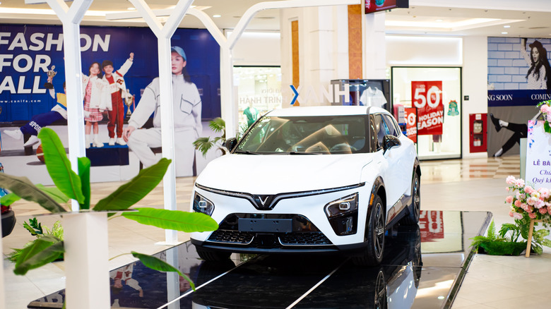 Brand new white VinFast electric car on display indoor at upscale Vincom shopping mall