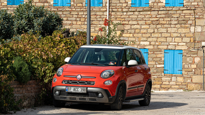 Fiat 500L car parked in front of a vintage wall with blue shutters