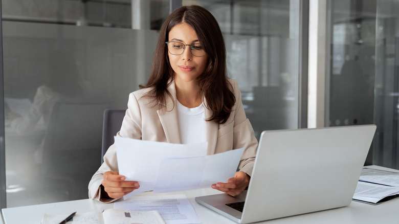 A young woman looking at tax documents in an office