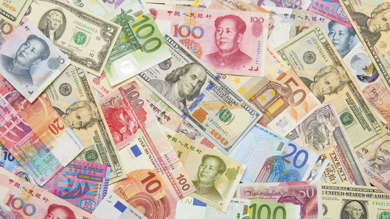 A pile of many different paper currency notes.