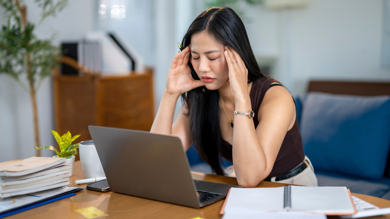 Woman with frustrated expression looking at a laptop screen