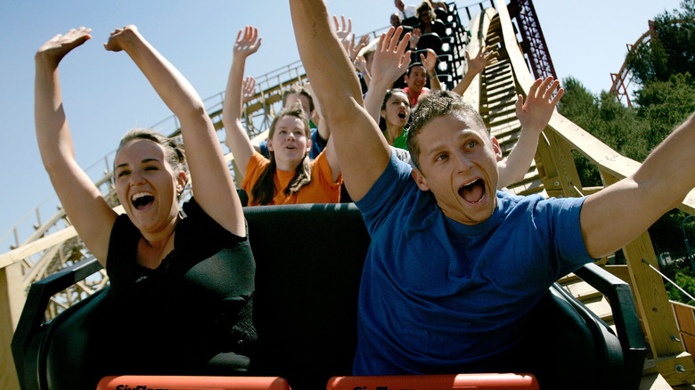Happy people riding a roller coaster