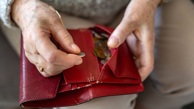 Close up of an hold woman's hands holding a wallet