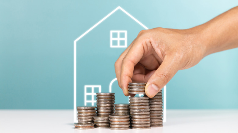 Outline of house with coins stacked in front
