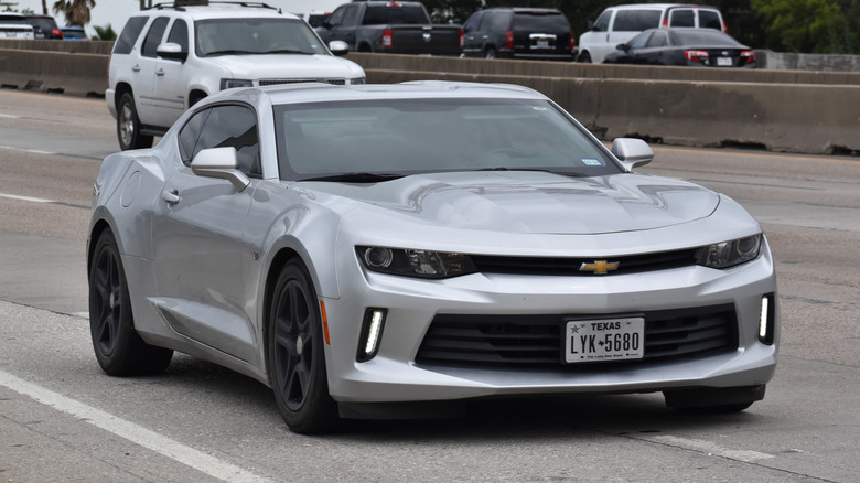 Silver Camaro driving on a street