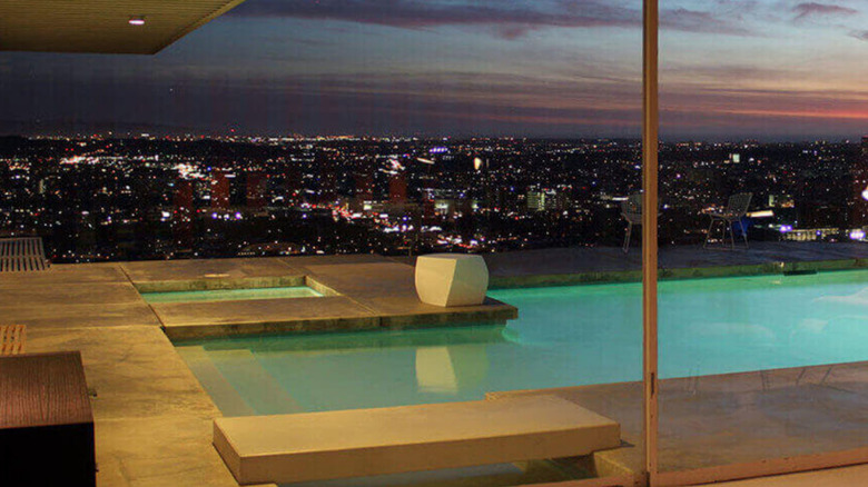 A nighttime view of the pool and city as the sun sets from the Stahl House