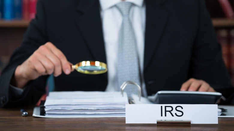 IRS auditor holding magnifying glass