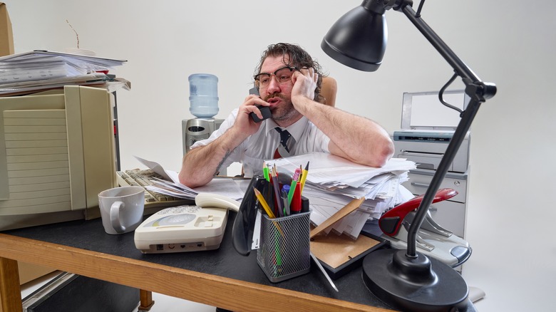 Man sitting at messy desk