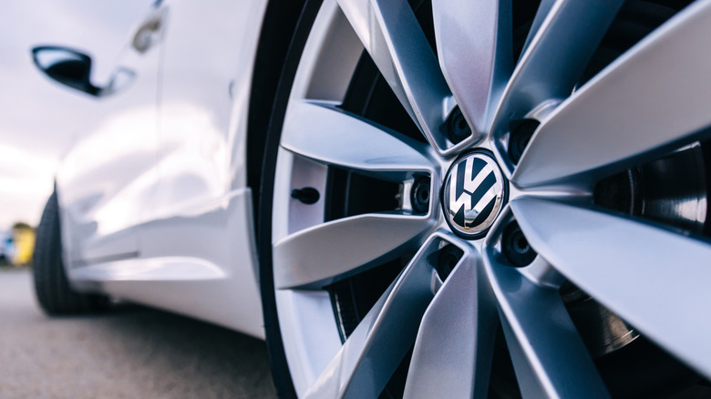 A close-up of a Volkswagen wheel on a white car.