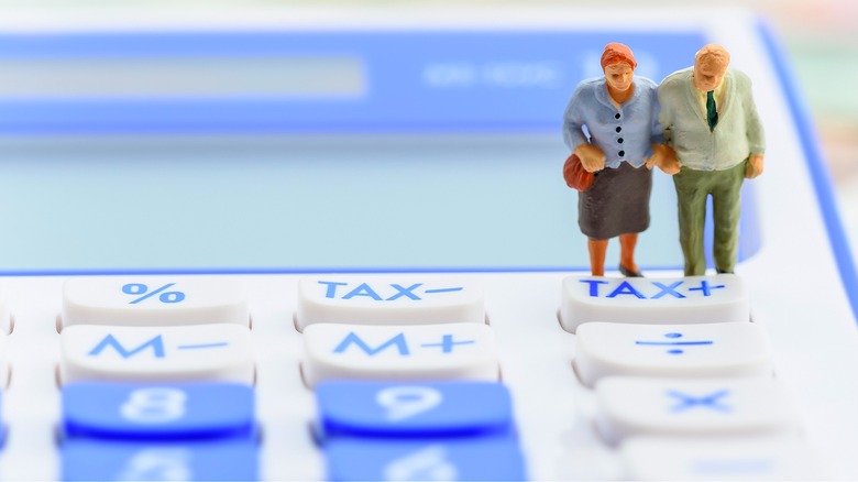 Elderly couple figurine on calculator