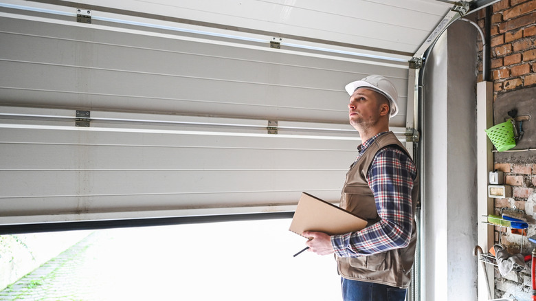 A construction working inspecting a garage door