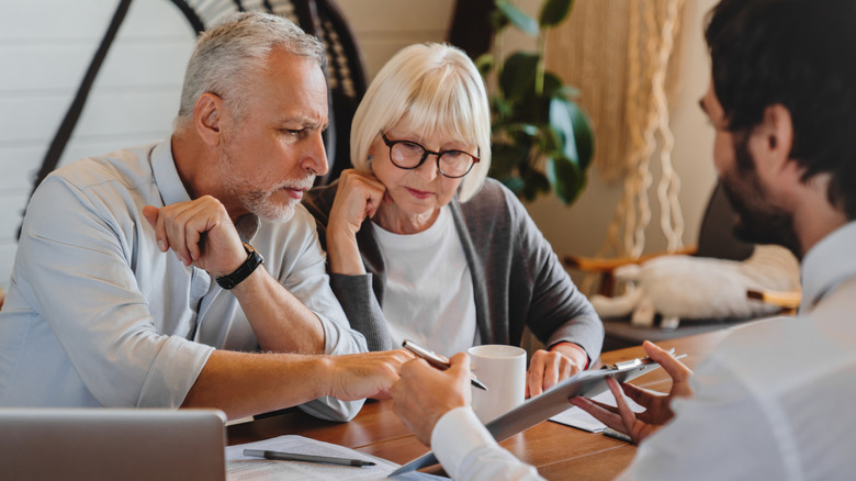 Old couple consulting agents about trust funds
