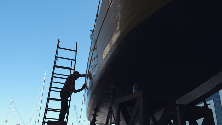 A yacht being worked on by a repairman