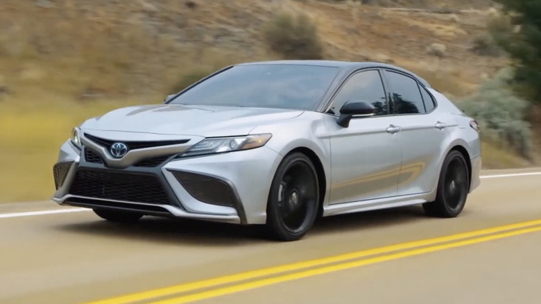 A silver 2022 Toyota Camry driving through a valley road