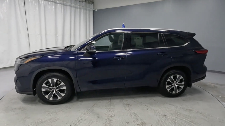 A dark blue 2022 Toyota Highlander in a showroom