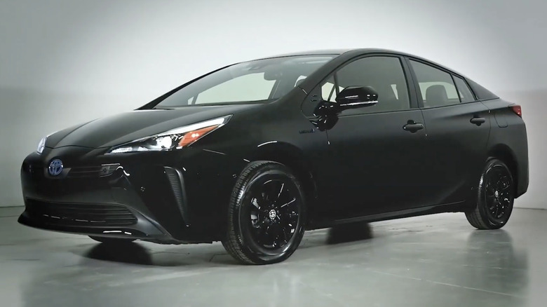 A black 2022 Toyota Prius nightshade edition on display in a white room