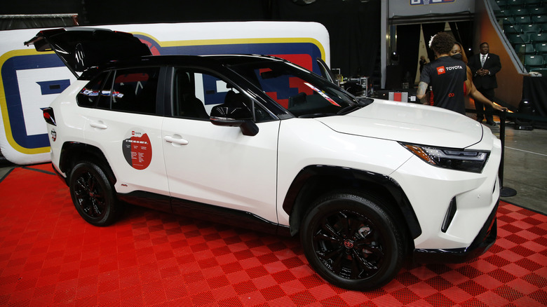 A white Toyota RAV4 displayed on a red mat at a car show