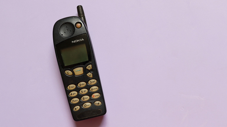 Old Nokia 5120 mobile phone isolated on purple background.