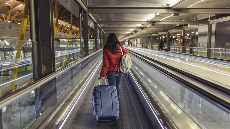 Woman walking through airport with luggage