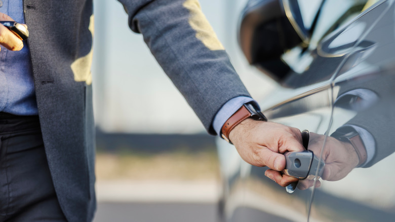 Man grabbing car door handle