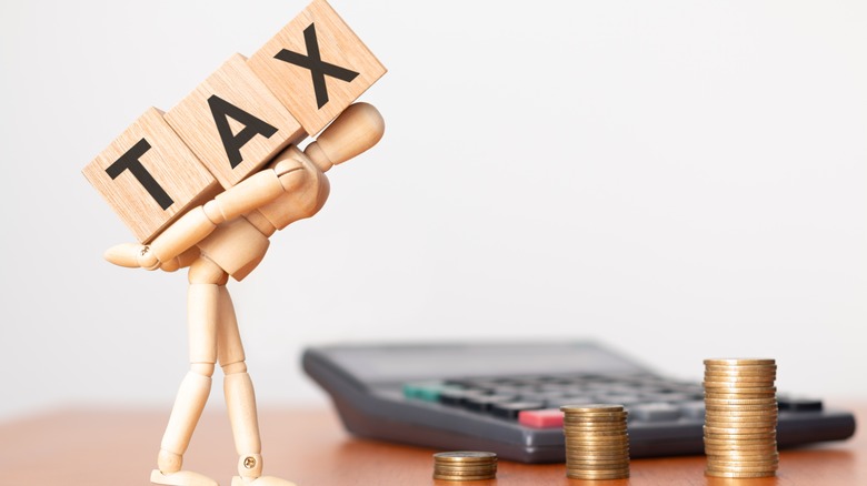 figurine holding tax blocks