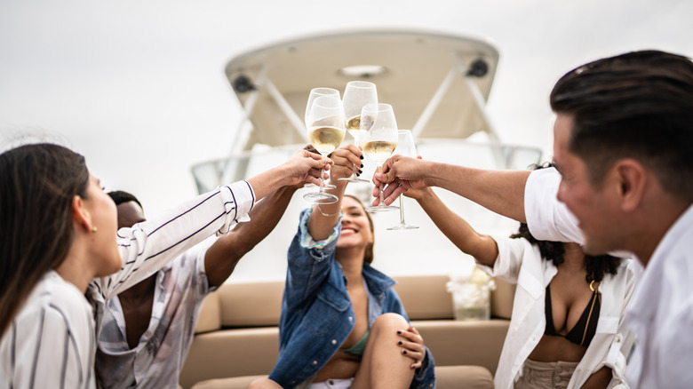 Group of young adults having a champagne toast on a boat
