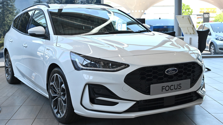 A new white Ford Focus on display in a showroom.