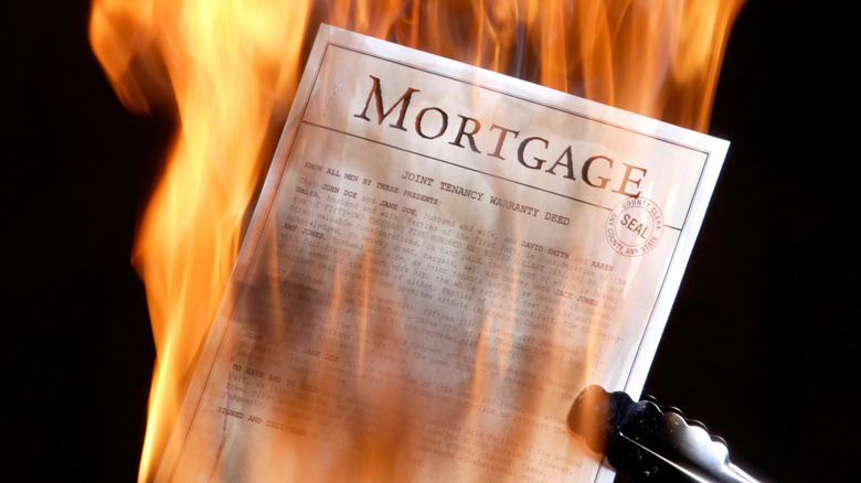 Mortgage papers being burned in a fire