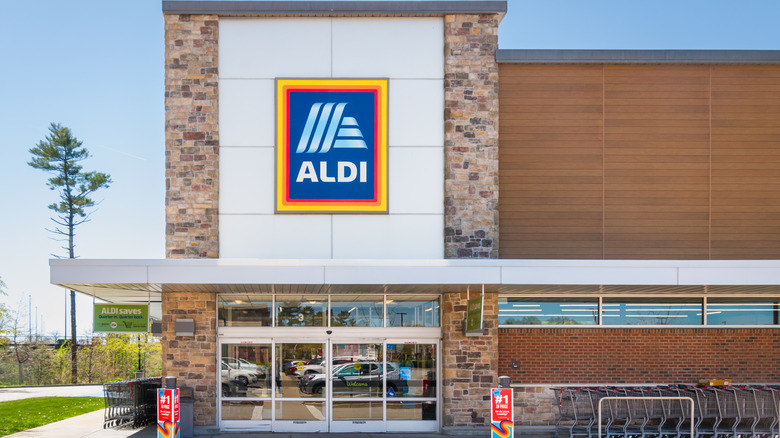 An Aldi storefront with quarter cart corral in view.