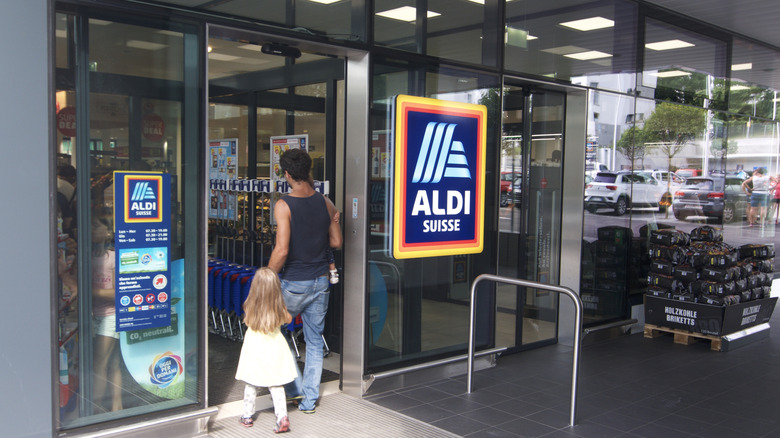 Woman and her child walking into an Aldi in Switzerland