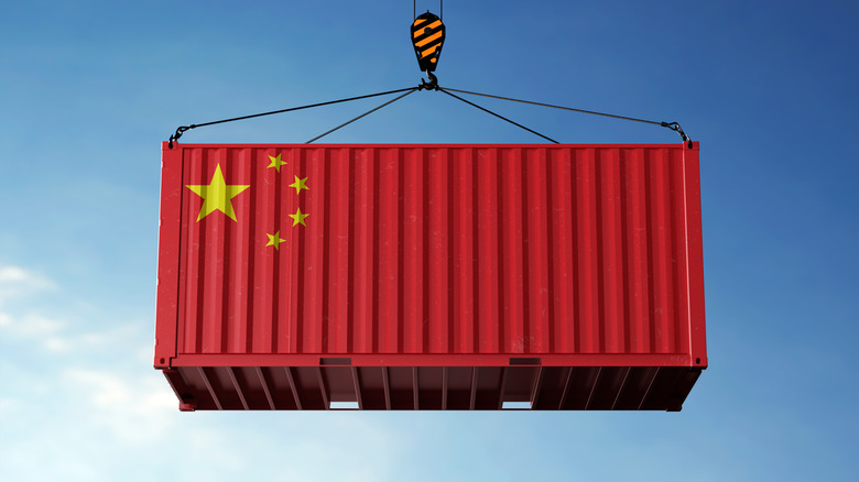 China trade cargo container hanging against clouds background