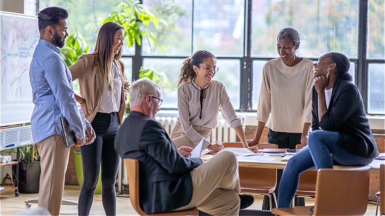 Happy employees gathered around table