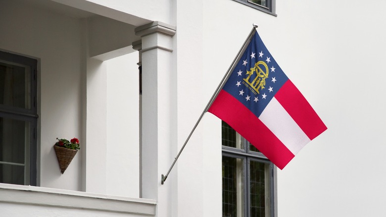 Georgia state flag blowing in breeze on front of building