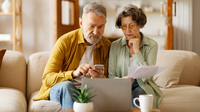 Two seniors appearing to pay bills while looking a computer screen