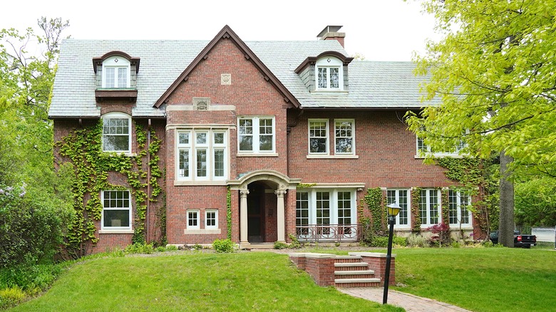 A large red brick home on a tree lined street in Highland Park, IL.