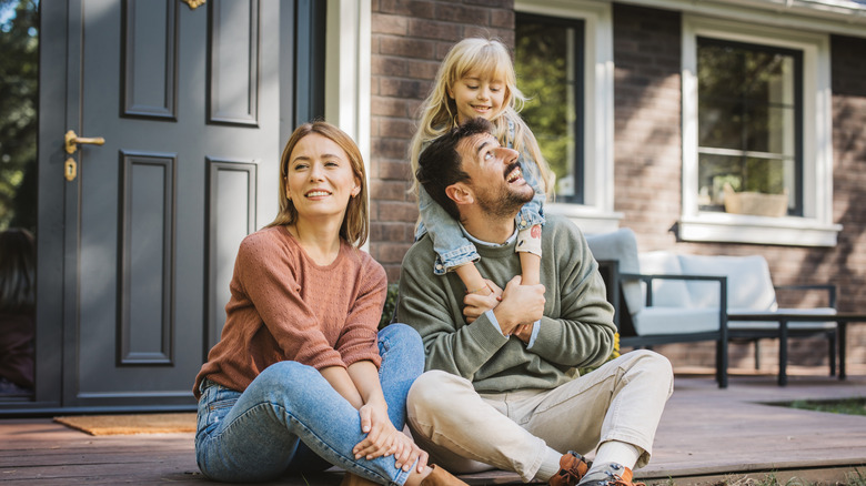 Young family in front of a house.