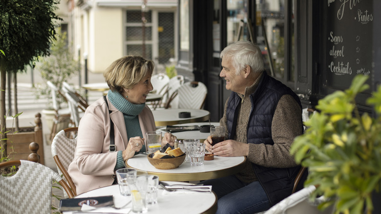 Older couple enjoying a meal at a French cafe