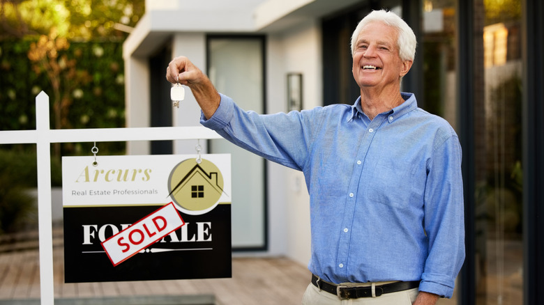 Wealthy older man holding the keys to a newly purchased property